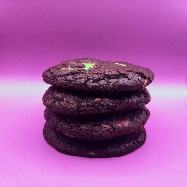 Stack of chocolate chip cookies on pink background